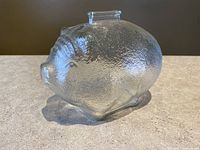 Side view of the piggy bank showing the textured clear glass and the pig shape