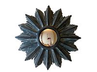 Full front view of the vintage starburst mirror showing ceramic black starburst frame and convex mirror center.