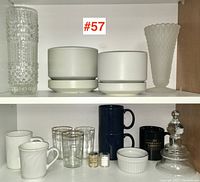 Full shelf view showing pottery and glassware assortment including Arabia pots, mugs, glasses, and decorative items