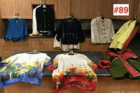 Wide view of all nine garments hung on cabinet handles and laid on counter