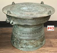 Full frontal view of bronze rain drum showing overall shape, size and patinated surface.