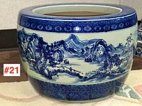 Front view of jardinière showing hand-painted blue and white landscape motif.