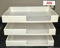 Top view of three stacked white plastic letter trays showing front openings and stacking design