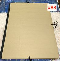 Storage portfolio with sheets of watercolor paper tied with black ribbons