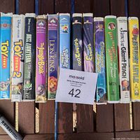 Photo of 12 assorted VHS movies including Toy Story, The Jungle Book, Lion King, Pokemon titles, Osmosis Jones, and more, showing spines and condition.