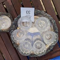 Top view of large silver tray holding six crystal goblets arranged in a circle showing bottom and rim details