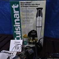 Cuisinart Smart Stick hand blender with attachments and original box displayed on table.