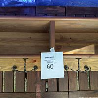 Top view of the wooden coatrack showing the solid wood grain and three iron hooks.