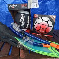Photo showing Rawlings football and soccer ball in box with snorkel fins and black fins on wooden surface
