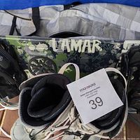 Lamar snowboard with graphic design and attached bindings along with snowboard boots.