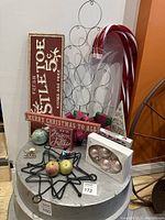 Christmas decorations including signs, metal star ornament holder with glass ornaments, and large candy cane decorations.