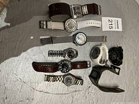 Photo showing all 10 men's wristwatches laid out on a surface, various styles and bands