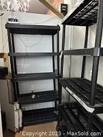 Multiple views of the black plastic shelving units showing five shelves each, made of grid style plastic shelves with four cylindrical posts at corners