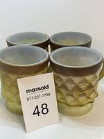 Four vintage Fire King Kimberly pattern mugs arranged in a group showing front and sides.