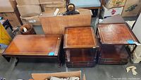Overall view of rectangular coffee table and two square end tables with leather inset tops, showing condition and style.