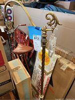 Full side view of the brass floor lamp showing its height and curved arm design with marble base.