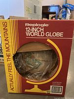 Photo of boxed Replogle 12-inch world globe showing front side with globe partially visible through plastic window