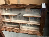 Front view of the carved wooden knick-knack shelf showing mirror backing and seven shelf sections.