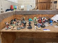 Wide view of approximately 40 figurines from Marvel, Star Wars, and Disney on a display surface, showing a variety of characters and poses.