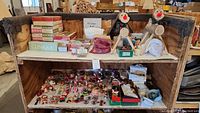 Photo showing two shelves filled with various vintage Christmas ornaments and handcrafted reindeer figurines.