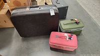 Overview of three vintage Samsonite luggage pieces: brown hard-sided suitcase, green Saturn cosmetic case, and pink Fashionaire 100 cosmetic case.
