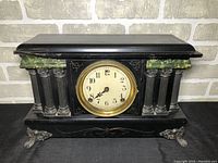 Front view showing clock face, surrounding columns with green marbled accents, and brass bezel.