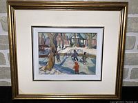 Framed oil painting depicting children ice skating in a winter park scene, showing the full artwork and frame.
