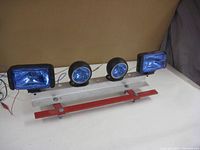 Four lights mounted on metal bracket in off state, showing assembly and wiring