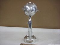 Front view showing the full cast metal piggy bank shaped like the Unisphere globe on a stand