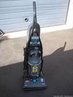 Full view of the Bissell upright vacuum cleaner showing handle, body, and base with power cord coiled on the side.