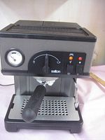 Front angle view of the black and silver Salton cappuccino coffee machine showing the pressure gauge, control knob, portafilter, and power buttons.