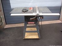 Front view of Craftsman 10-inch table saw with cast iron table and attached fence, mounted on plywood base with casters.