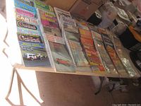 Lot of vintage car magazines spread on a folding table with visible titles including Old Car, Hot Rod, and Super Street Cars