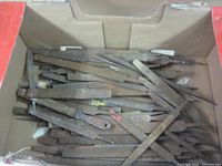 Box with a pile of metal files showing rust and wear, some with missing handles.