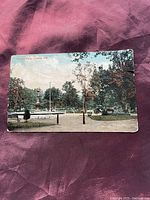 Front side of the postcard showing Victoria Park, London, Ontario with a color image of the park landscape, fountain, and trees.