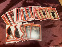 Stacked Moonraker trading card backs and fronts showing character images in red-bordered cards and stickers cut out with character shapes.