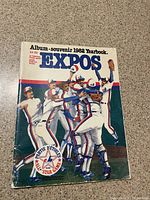 Front cover of 1982 Montreal Expos album souvenir yearbook showing illustrated celebrating players and MLB and Expos logos.