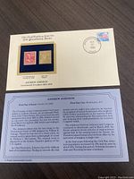 Presentation card showing both the 1938 U.S. postage stamp and a gold replica stamp mounted side by side with a first day of issue cancellation mark dated October 27, 1938.