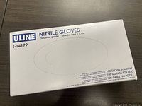 Top view of unopened box showing ULINE branding, nitrile gloves, industrial grade, powder-free, 4 mil, size large (S-14179). 100 gloves by weight specified.
