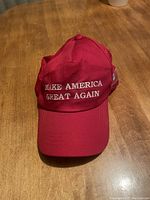 Front view of red baseball cap with white embroidered 'MAKE AMERICA GREAT AGAIN' text.