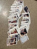 Overview of many hockey trading cards spread on a countertop showing front sides with player images and stats.