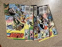 Photo showing six G.I. Joe comic books stacked with issue numbers visible on spines and front cover edges.