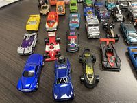 Top view of various toy cars arranged on a table showing a blue car, a McDonald's themed car, and other assorted models in rows.