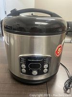 Front view of the stainless steel Hamilton Beach Digital Simplicity rice cooker and steamer with digital control panel and black lid handle.