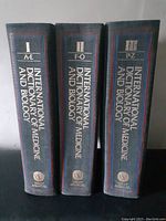 Spines of the three volumes showing volume numbers and alphabetical range covered.