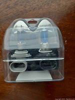 Two new car halogen headlight bulbs in clear plastic packaging