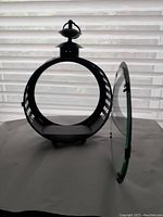 View of the metal circular lantern with open glass door showing interior platform for candle or light.