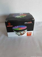 Photo of Coolmoon V2 RGB processor fan box showing the fan with RGB lighting and copper heat pipes.