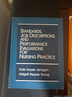 Blue hardcover book titled 'Standards, Job Descriptions, and Performance Evaluations for Nursing Practice' by Dale Kayser Jernigan and Abigail Pepper Young.