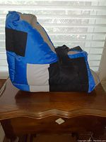 Side view of the Heel Protector showing blue, black, and gray colors, and hook-and-loop securing straps.